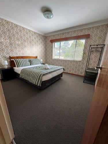 a bedroom with a bed and a window at Casa Sarina in Stanthorpe