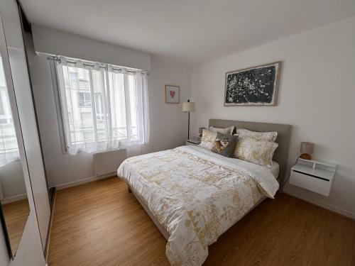 a white bedroom with a bed and a window at F2 calme et lumineux avec balcon au cœur du Vieux Lille in Lille
