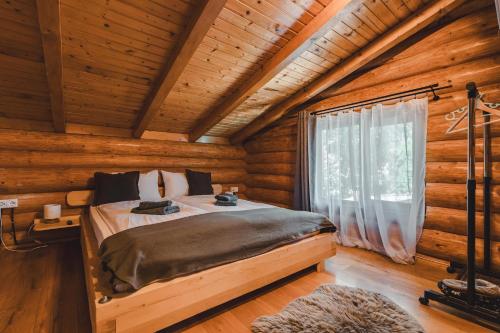 a bedroom with a bed in a log cabin at Holzhaus in Sadu