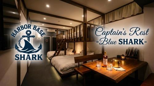 a bedroom with a bed and a sign for a ship at Harbor base SHARK in Sado