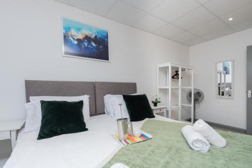 a bedroom with a large white bed with green sheets and pillows at Open Mind Property - Spacious 2BR Flat City Views in Portsmouth