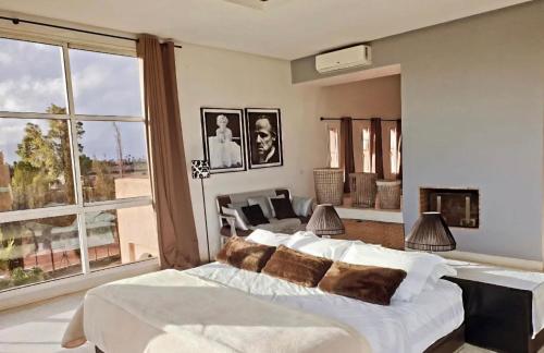 a bedroom with a large bed and a living room at Villa Loanaelle in Marrakesh