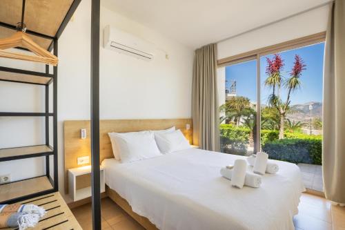 a bedroom with a bed and a large window at Renata's Villas in Karpathos
