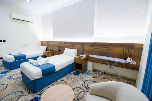 a hotel room with two beds and a chair at فندق عصفور 03 in Mecca