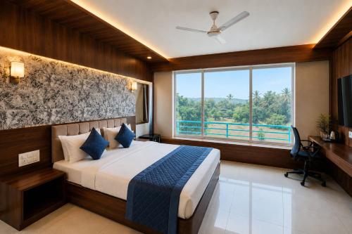 a bedroom with a bed and a large window at High Five Hotels Phase 2 in Assagao