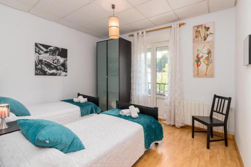 a bedroom with two beds and a chair and a window at Casa independiente entre mar y montaña in Puente San Miguel