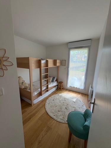 a room with two bunk beds and a rug at Appartement avec piscine chauffée et Tennis proche Deauville in Touques
