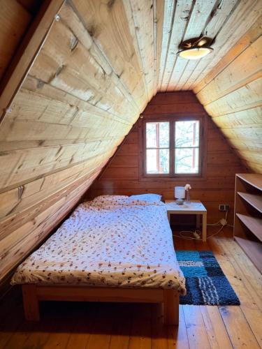 a bedroom with a bed in a attic at Leśny Zakątek Nowy Wiśnicz in Nowy Wiśnicz