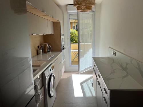 a kitchen with a washer and dryer in it at Appartement avec piscine chauffée et Tennis proche Deauville in Touques