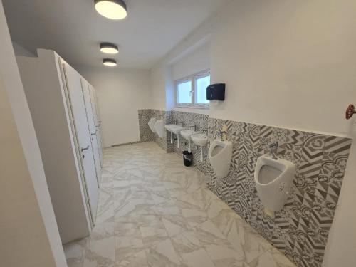 a bathroom with a row of urinals on the wall at Hostel P16 in Zagreb