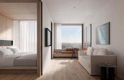 a bedroom with a bed and a couch and a window at Little National Hotel Adelaide in Adelaide
