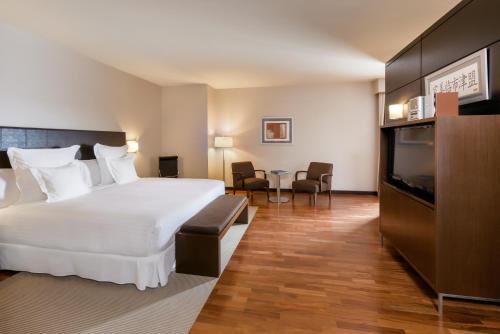ein Hotelzimmer mit Bett und Flachbildfernseher in der Unterkunft Occidental Aranjuez in Aranjuez