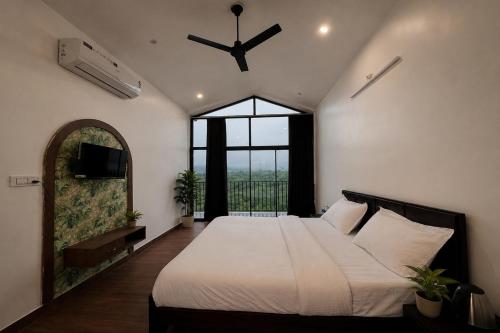 a bedroom with a large bed and a large window at VANVASS - A Forest Resort By Rovers in Rāma