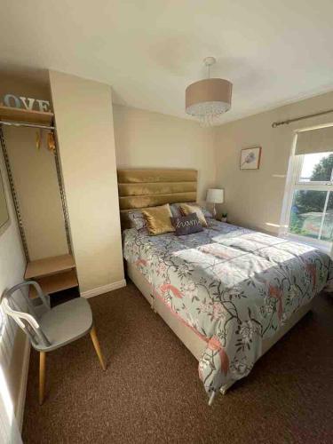 a bedroom with a bed and a chair and a window at Murlough View in Dundrum