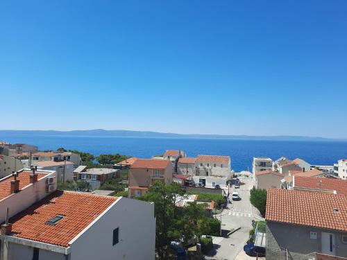 a view of a town with the ocean in the background at Danica Roof in Tučepi