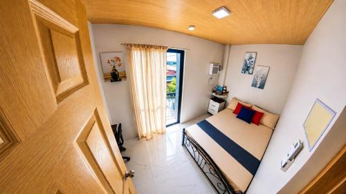 a bedroom with a bed and a door to a balcony at CLBC Residences - 2B in Ibaba