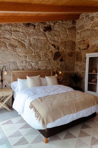 a bedroom with a bed in a stone wall at Casa Chare in Moaña