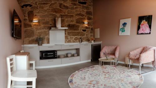 a kitchen with a table and chairs and a stone wall at Casa Chare in Moaña
