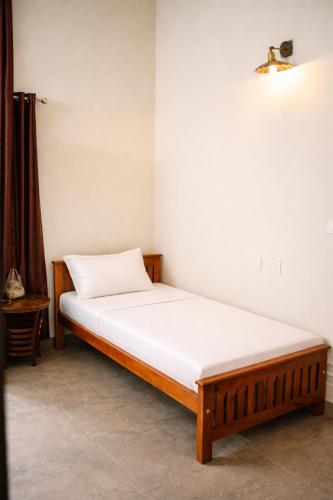 a bed in a room with a white mattress at Mistnview By SHELTERS in Meppādi