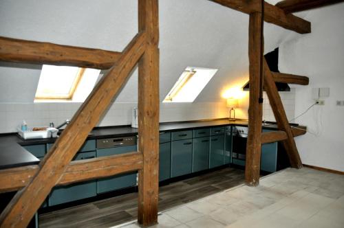 a kitchen with blue cabinets and two skylights at Cafe-Kuckuck in Salzwedel