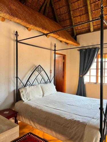 a bedroom with a large bed with a metal frame at Kudu Plaas - Wildlife on your doorstep in Beestekraal