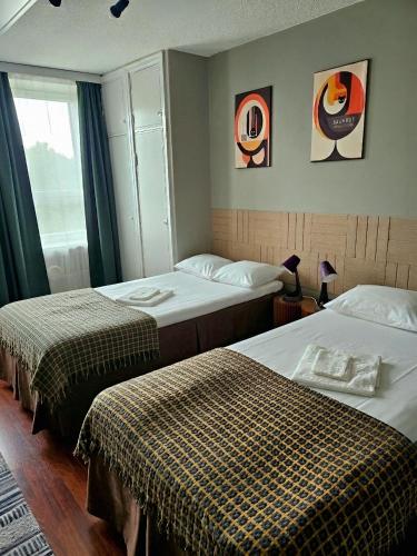 a hotel room with two beds and a window at Hotel Suonenjoki in Suonenjoki