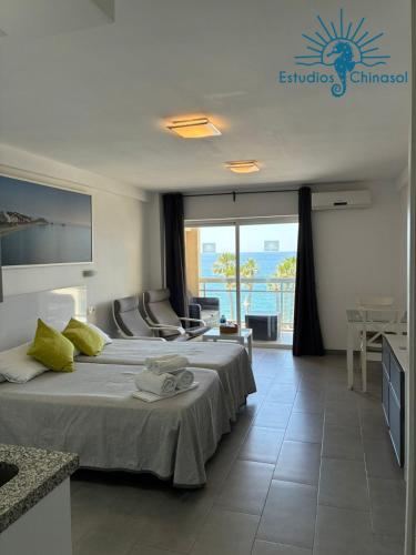 a hotel room with a bed and a view of the ocean at ESTUDIOS CHINASOL - Bernardo Cózar in Almuñécar