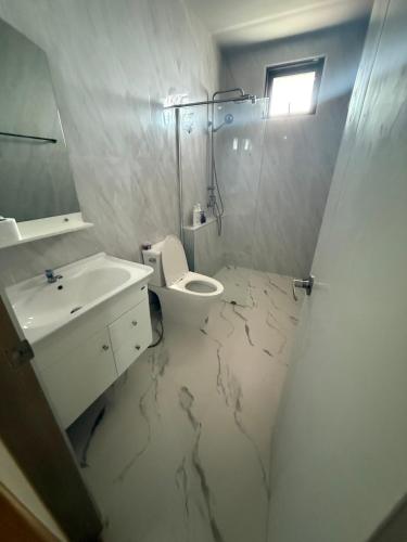 a bathroom with a toilet and a sink and a shower at The Hide Private in Ban Non Sa-at