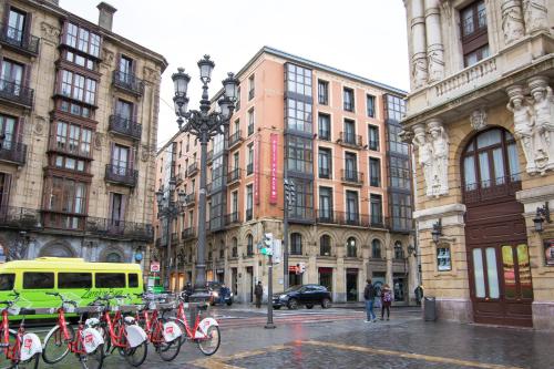 een groep fietsen geparkeerd in een stadsstraat bij Petit Palace Arana Bilbao in Bilbao