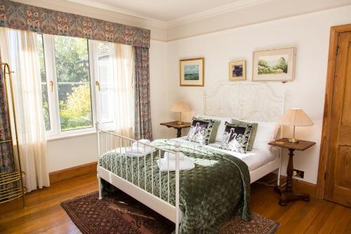 ein Schlafzimmer mit einem Bett mit grüner Bettdecke in der Unterkunft Whitebeams in Canterbury