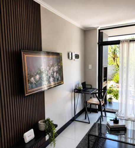 a living room with a painting on the wall at Garden View Suite in Gqeberha