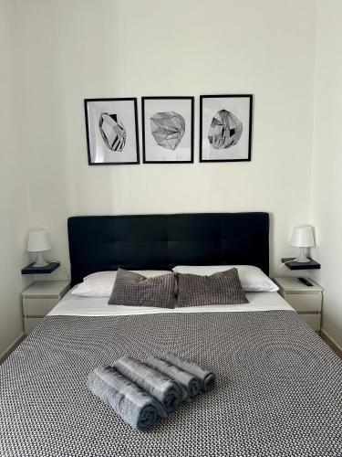 a bedroom with a bed with three pictures on the wall at Modern apartment - Salento Guest House in Monteroni di Lecce
