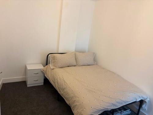 a small bedroom with a bed and a night stand at Pork pie pad in Melton Mowbray