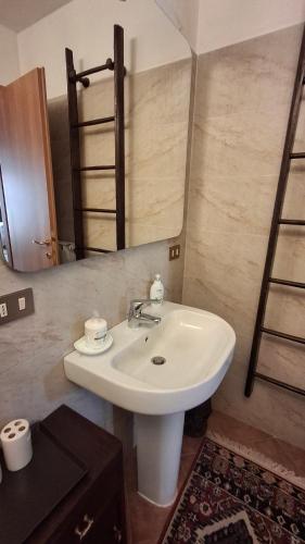 Casa Vacanze CIMMO في Tavernole sul Mella: حمام به حوض غسيل أبيض ومرآة
