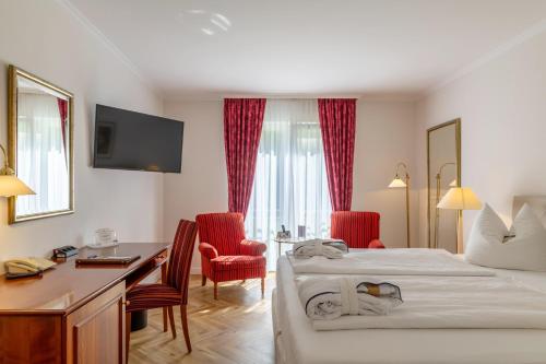 a hotel room with a bed and a desk and chairs at Hotel Döllnsee-Schorfheide in Templin