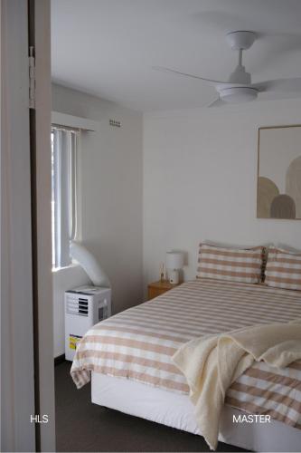 a white bedroom with a bed and a window at Harbour Lane Stay in Geraldton