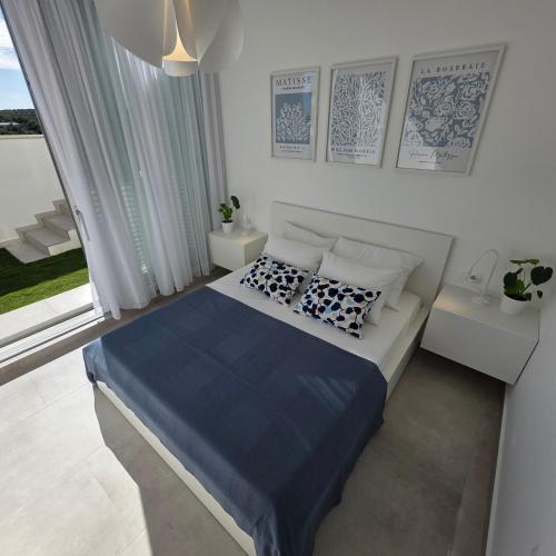 a bedroom with a bed with blue sheets and pillows at Sunrise & Sunset villa Šimuni by Pag tours in Šimuni