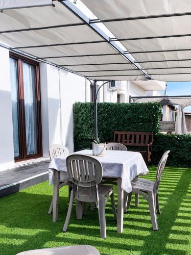 a table and chairs under an umbrella on a lawn at Villa Katia - Affittacamere in Torre Marino