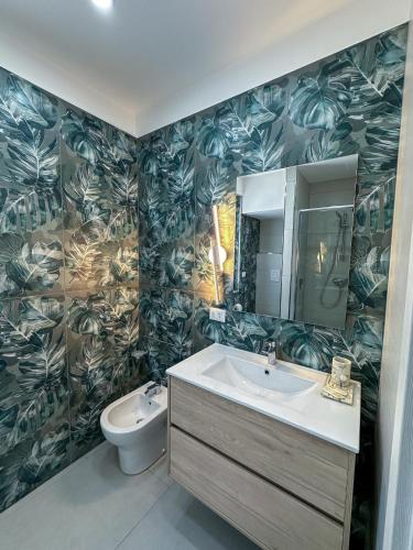 a bathroom with a sink and a toilet at Beach House - Affittacamere Paola in Paola