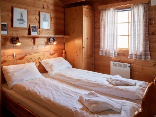 a bedroom with a bed in a wooden room at Fjellro in Stranda