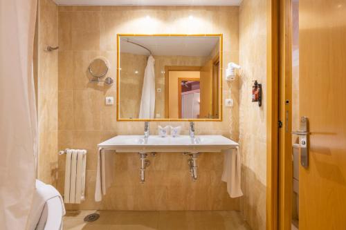 a bathroom with a sink and a mirror at Hotel Parasol by Dorobe in Torremolinos