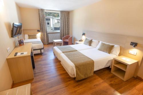 ein Hotelzimmer mit einem großen Bett und einer Couch in der Unterkunft Hotel Panorama in Andorra la Vella
