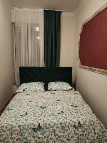 a bedroom with a bed with a green headboard and a window at Pokoje U Cyngla in Mielec