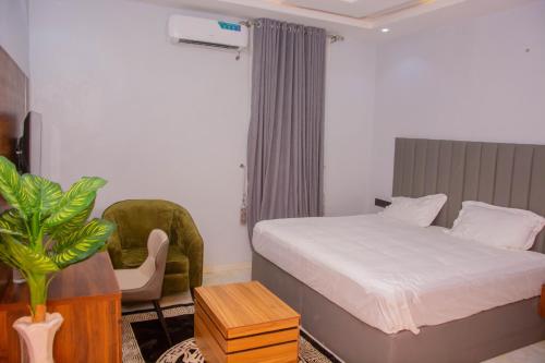 a hotel room with a bed and a chair at Five Star Meekness Hotel LTD in Oviri