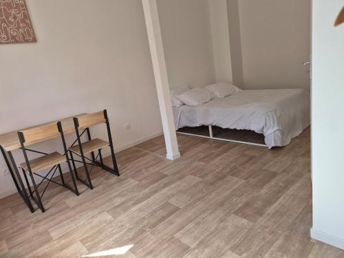 a small room with a bed and a table and chairs at Maison chaleureuse avec tous confort in Elbeuf