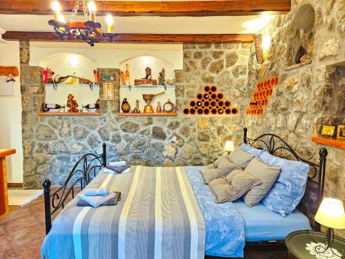 a bedroom with a bed and a stone wall at Apartman Ruza 3 in Poljane