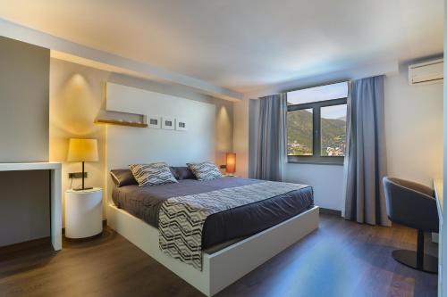 ein kleines Schlafzimmer mit einem Bett und einem Fenster in der Unterkunft Hotel Panorama in Andorra la Vella