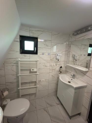 ein Badezimmer mit Toilette, Waschbecken und Fernseher in der Unterkunft A-Frame Prislop,Hațeg in Silvaşu de Sus