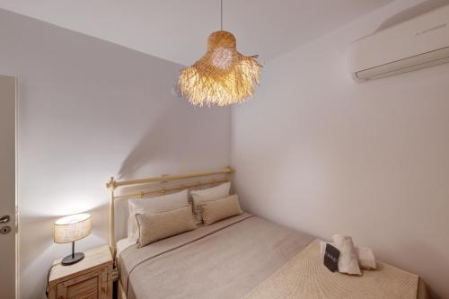 a small bedroom with a bed and a lamp at Villa Marelia - Seafront villa with infinity pool in Megas Gialos - Nites