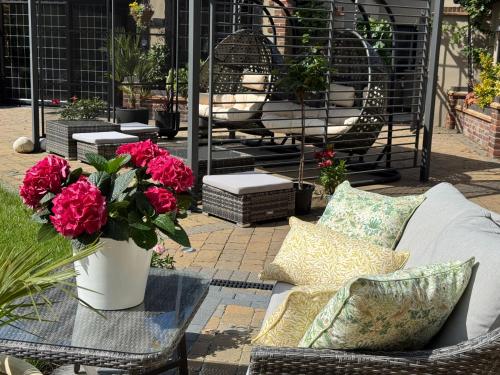 a patio with a couch and flowers and tables at Balancyoga Guesthouse in Ash